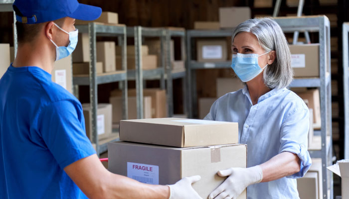 Temporärarbeit: Mitarbeiter übergibt Paket